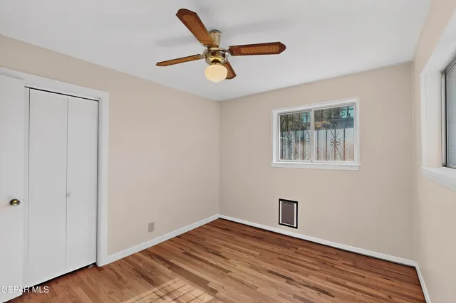 a view of a livingroom with wooden floor and a ceiling fan