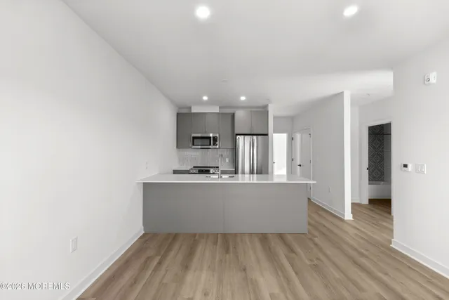 a view of kitchen with stainless steel appliances wooden floor