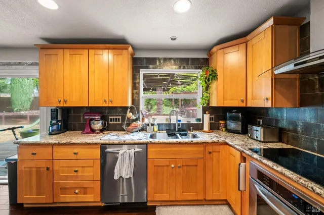 a kitchen with a refrigerator a stove a sink and a window