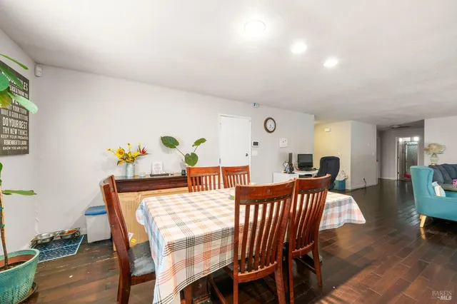 a kitchen with a sink a stove and chairs with wooden floor