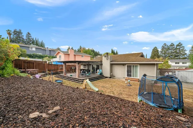 a view of a backyard with swimming pool and sitting area