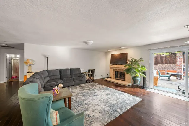 a living room with furniture a fireplace and a flat screen tv