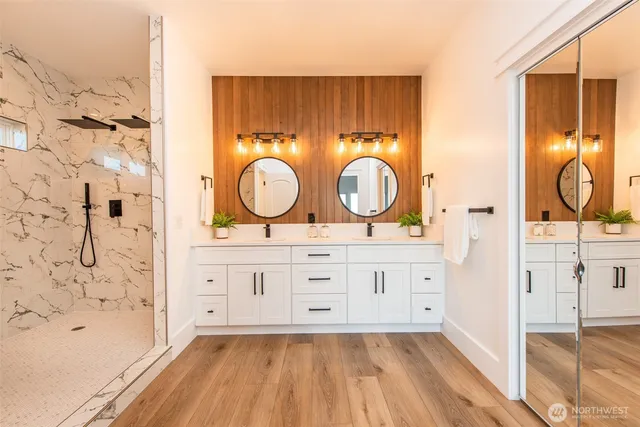 a bathroom with a double vanity sink mirror and shower