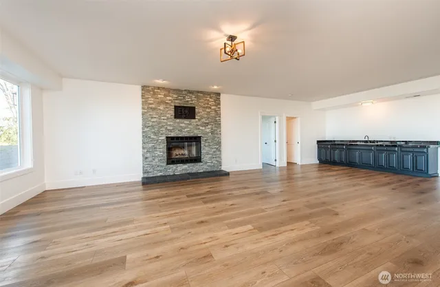 a view of empty room with wooden floor and fireplace