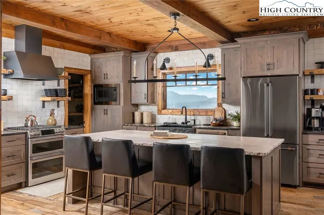 a kitchen with stainless steel appliances a stove a sink refrigerator and a refrigerator