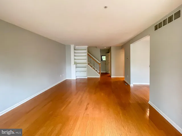 a view of empty room with wooden floor