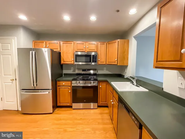 a kitchen with stainless steel appliances granite countertop a refrigerator a sink a stove a microwave and island