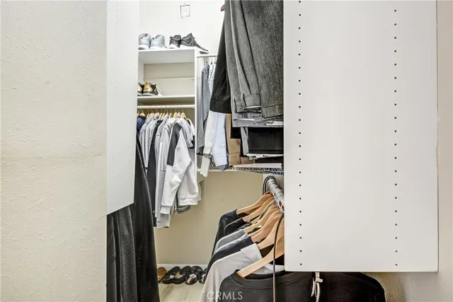 a view of walk in closet with clothes