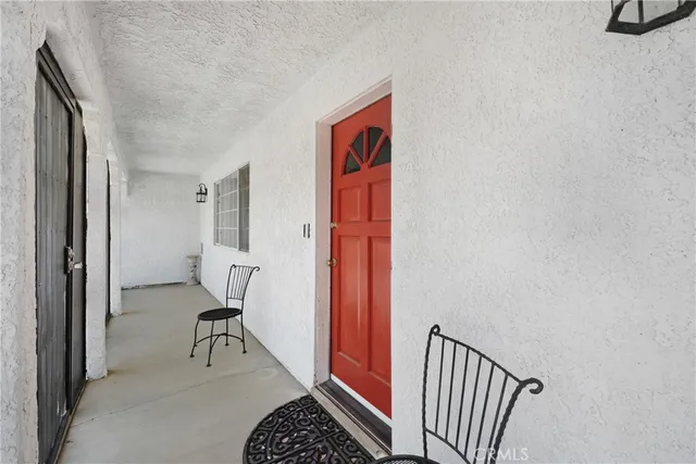 a view of a hallway with wooden floor and a bathroom