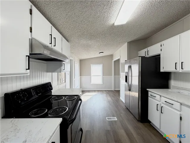 a kitchen with a stove a sink and a refrigerator