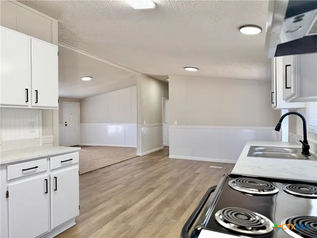 a kitchen with a stove and white cabinets