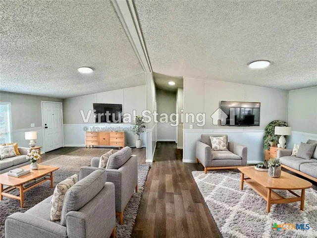 a living room with furniture and a wooden floor