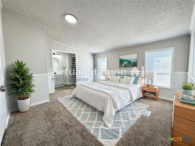 a bedroom with a large bed and a potted plant