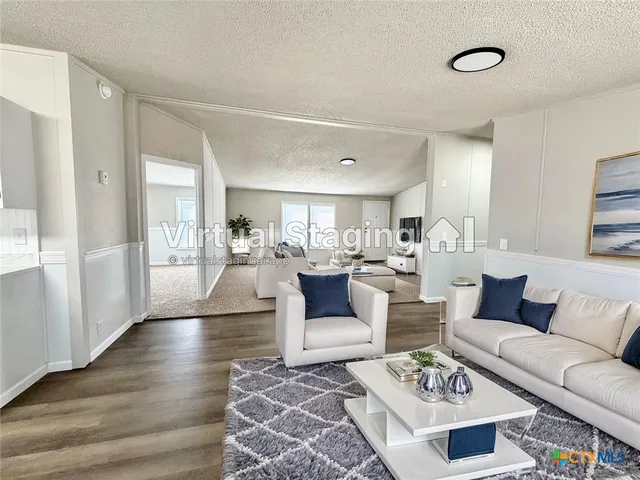 a living room with furniture wooden floor and a view of kitchen