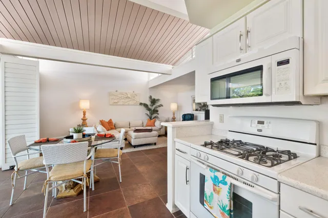 a living room with furniture a flat screen tv and kitchen view