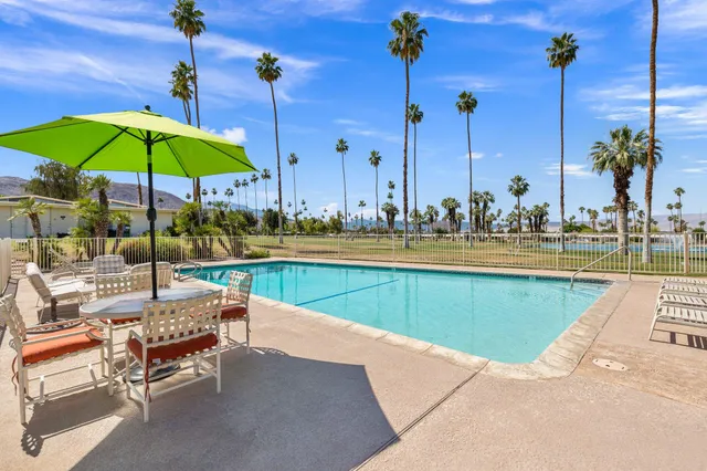 a view of a patio with a table and chairs under an umbrella