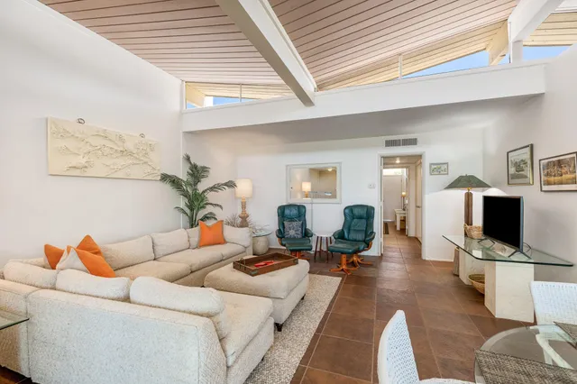 a living room with furniture a rug and a window