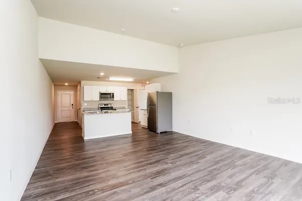 a view of kitchen with stainless steel appliances wooden floor and large window
