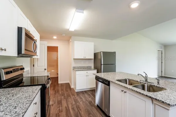 a kitchen with granite countertop a sink and a stove top oven