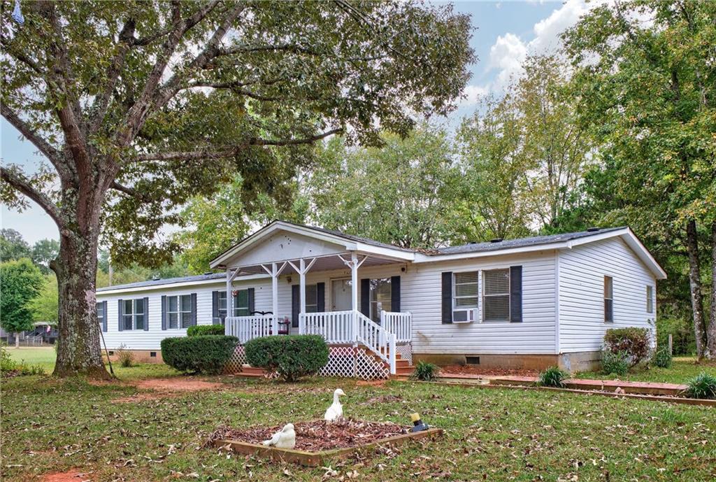 a front view of a house with a yard and trees
