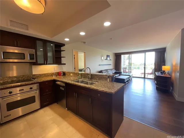 a large kitchen with stainless steel appliances granite countertop a stove and a sink