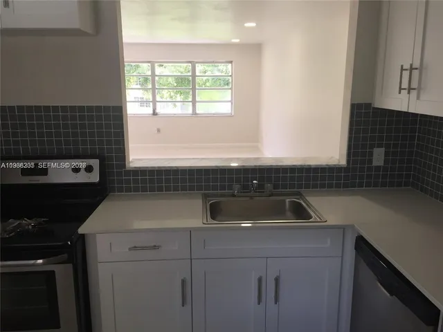 a kitchen with a refrigerator and a sink
