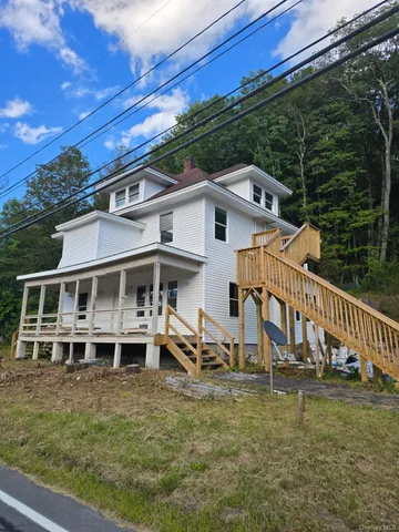 a view of a house with backyard and porch