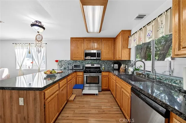 a kitchen with stainless steel appliances granite countertop a sink and a stove
