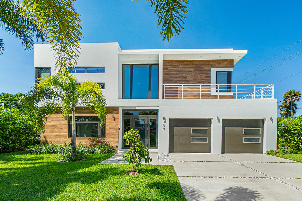 a front view of a house with a garden and plants
