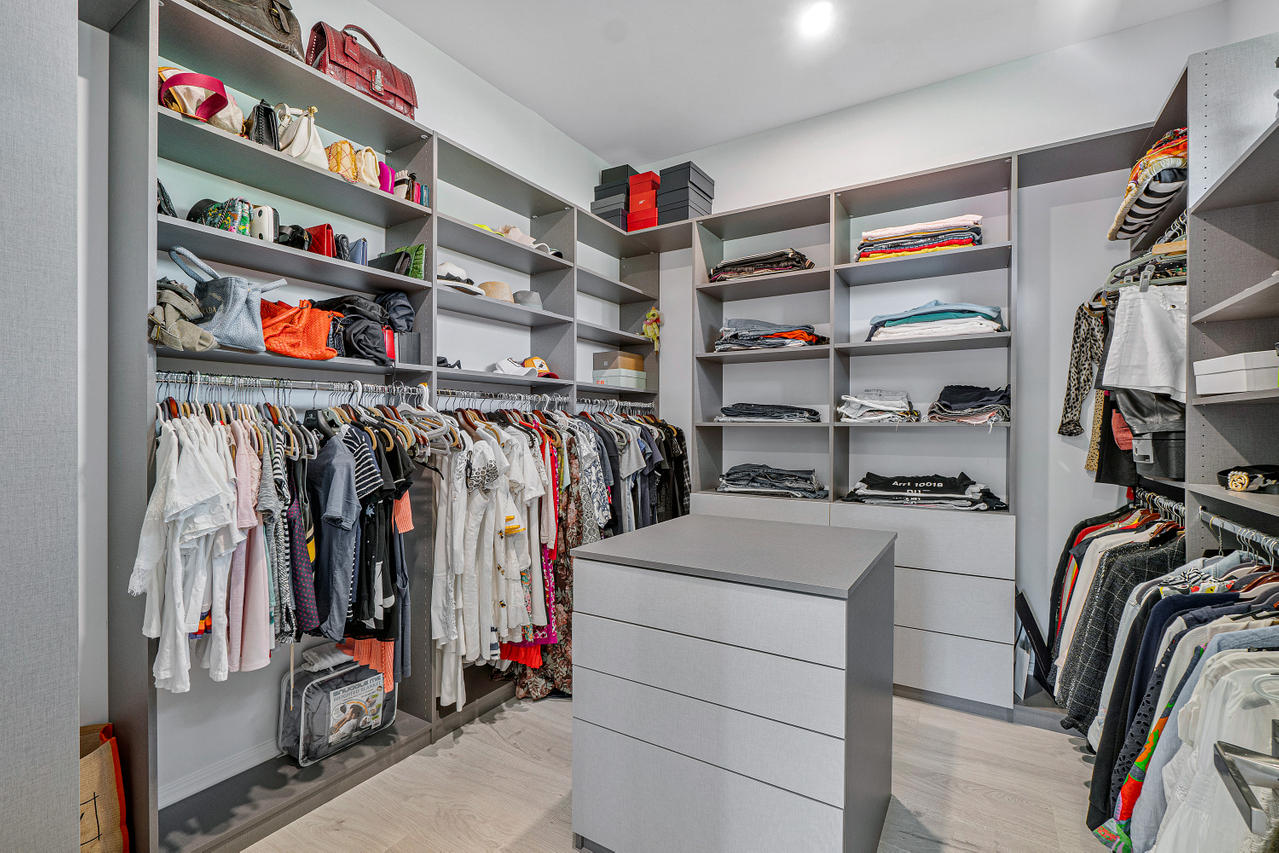 709 Northwest 6th Drive Boca Raton, FL 33486 - Photo 12 of 20 a view of walk in closet with clothes and shoes