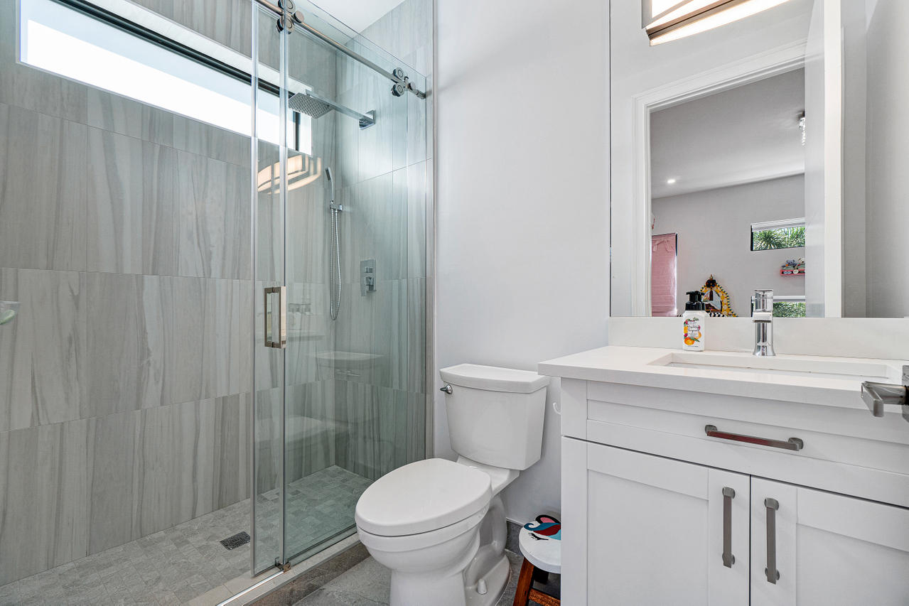709 Northwest 6th Drive Boca Raton, FL 33486 - Photo 18 of 20 a bathroom with a sink toilet and shower