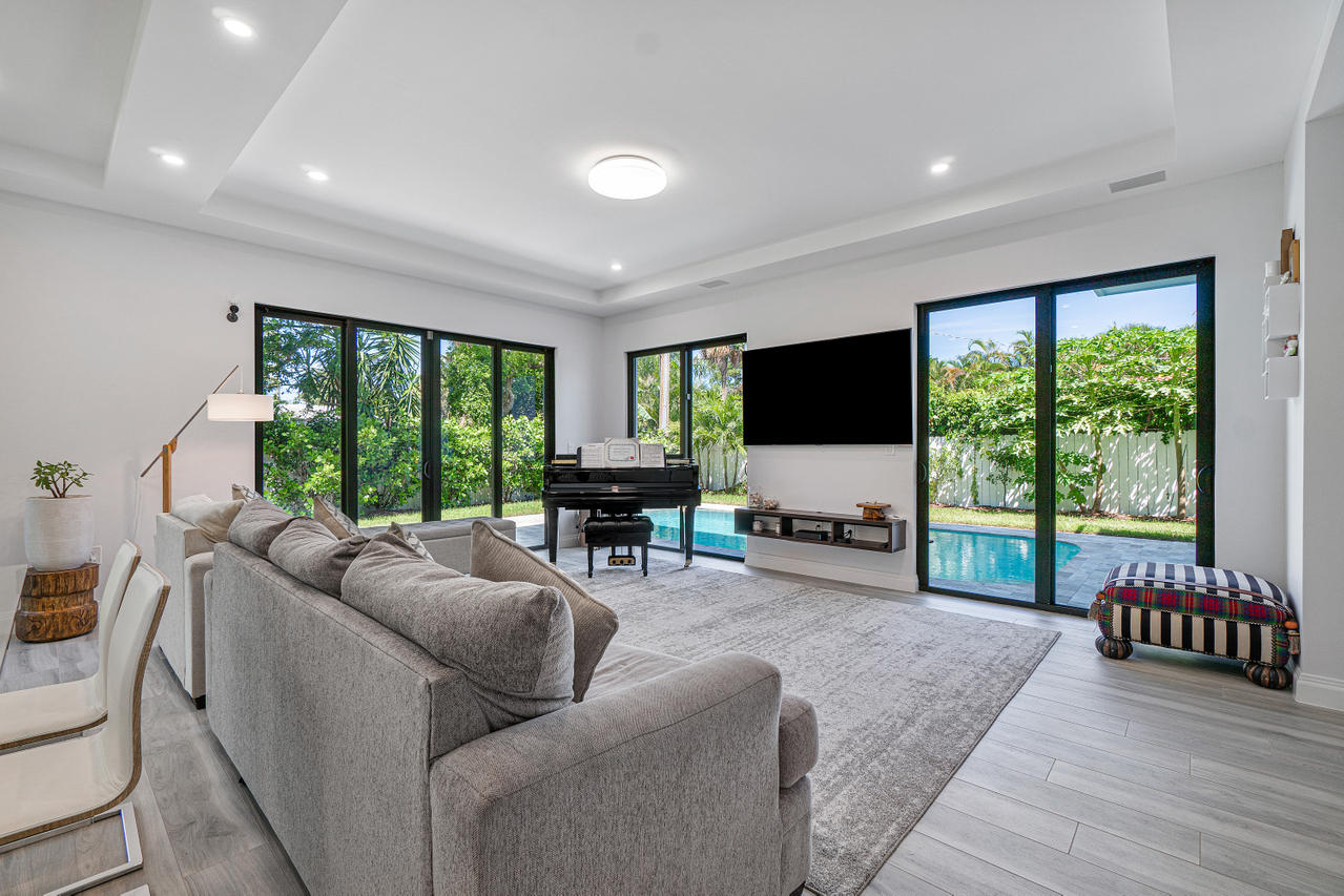 709 Northwest 6th Drive Boca Raton, FL 33486 - Photo 4 of 20 a living room with furniture a flat screen tv and a large window