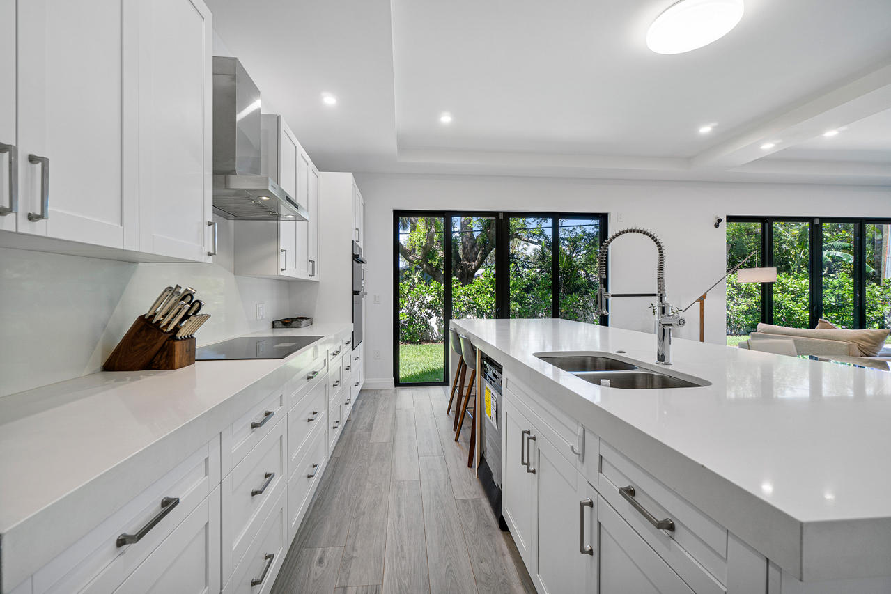 709 Northwest 6th Drive Boca Raton, FL 33486 - Photo 7 of 20 a kitchen with stainless steel appliances a sink stove and cabinets