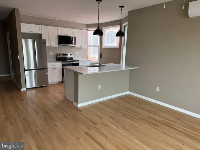 a kitchen with kitchen island white cabinets and stainless steel appliances