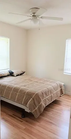 a bedroom with a bed and wooden floor