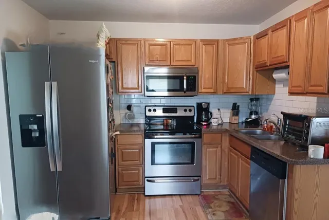 a kitchen with stainless steel appliances granite countertop a refrigerator stove and microwave