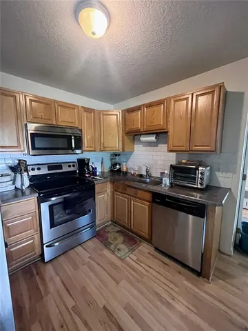 a kitchen with sink a microwave a stove and cabinets