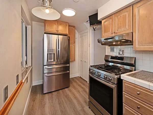 a kitchen with stainless steel appliances granite countertop a stove a refrigerator and a microwave