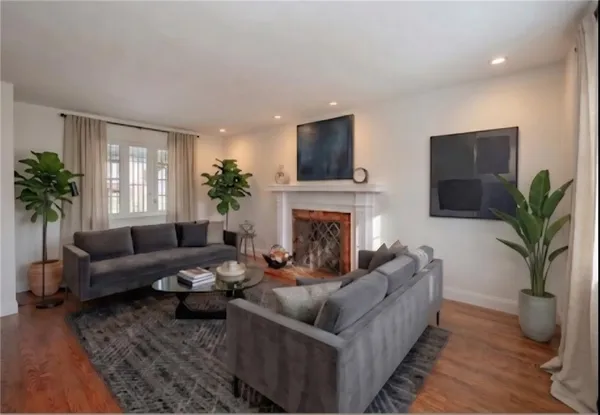 a living room with furniture a flat screen tv and a fireplace