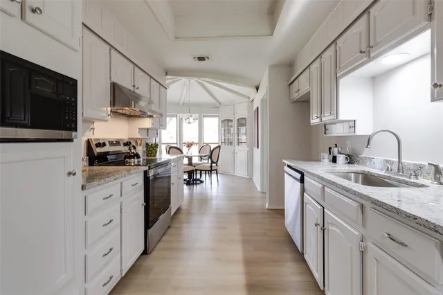 a kitchen with cabinets a sink and appliances