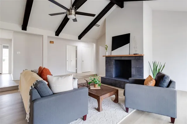 a living room with furniture a flat screen tv and a fireplace