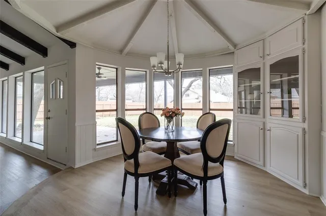 a dining room with furniture a chandelier and wooden floor