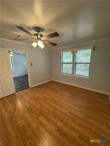 an empty room with windows and fan