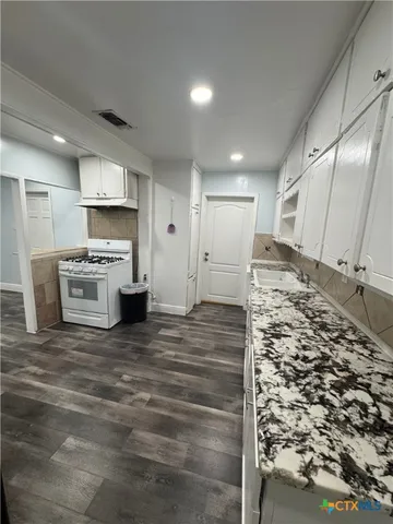 a view of a kitchen with a sink and a refrigerator