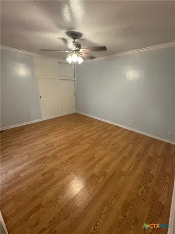 a view of an empty room with a chandelier fan