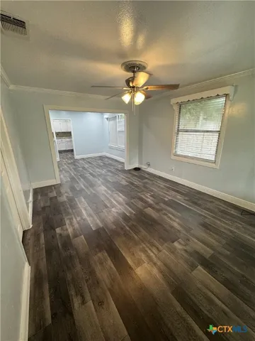 en empty room with windows and ceiling fan