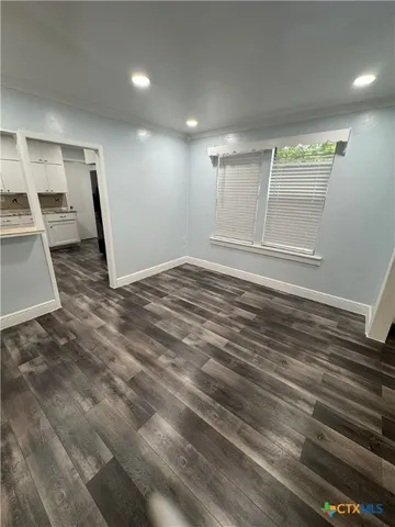 a view of empty room with wooden floor
