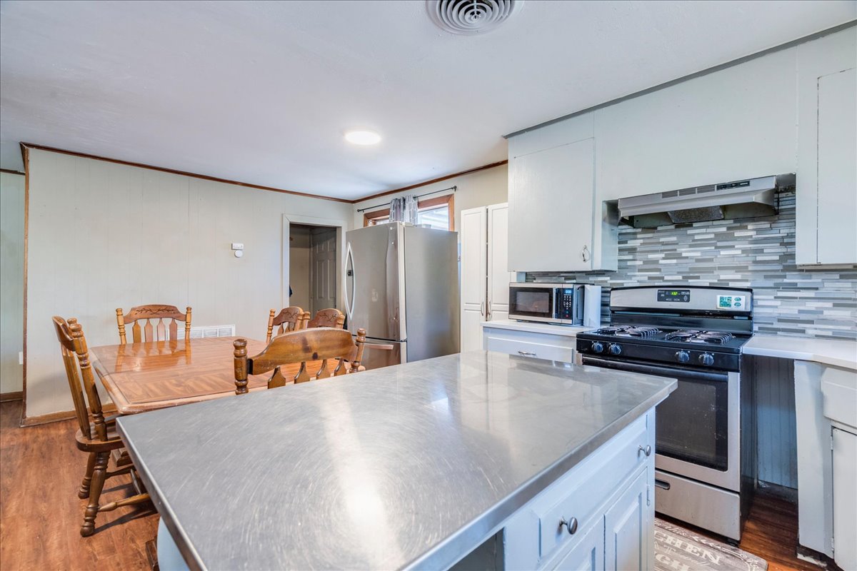 500 Blackjack Street Lockhart, TX 78644 - Photo 12 of 27 Kitchen with stainless steel appliances, white cabinetry, light wood-type flooring, a kitchen island, and ventilation hood