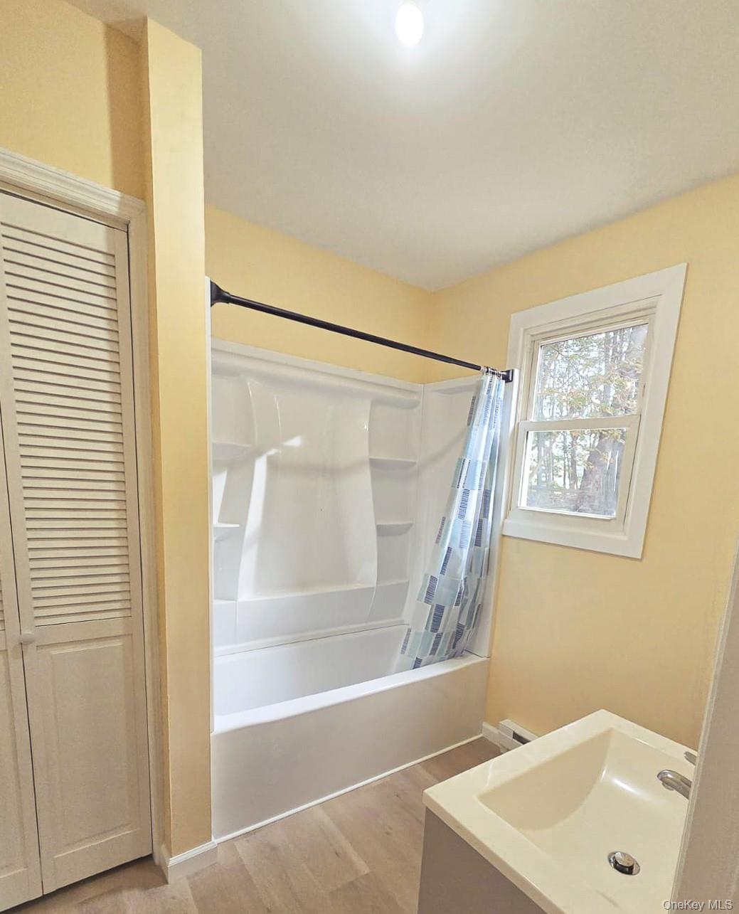 8 Cottage Street, Unit 1 Monticello, NY 12701 - Photo 9 of 9 Full bathroom featuring shower / tub combo with curtain, vanity, light wood-style flooring, and a closet
