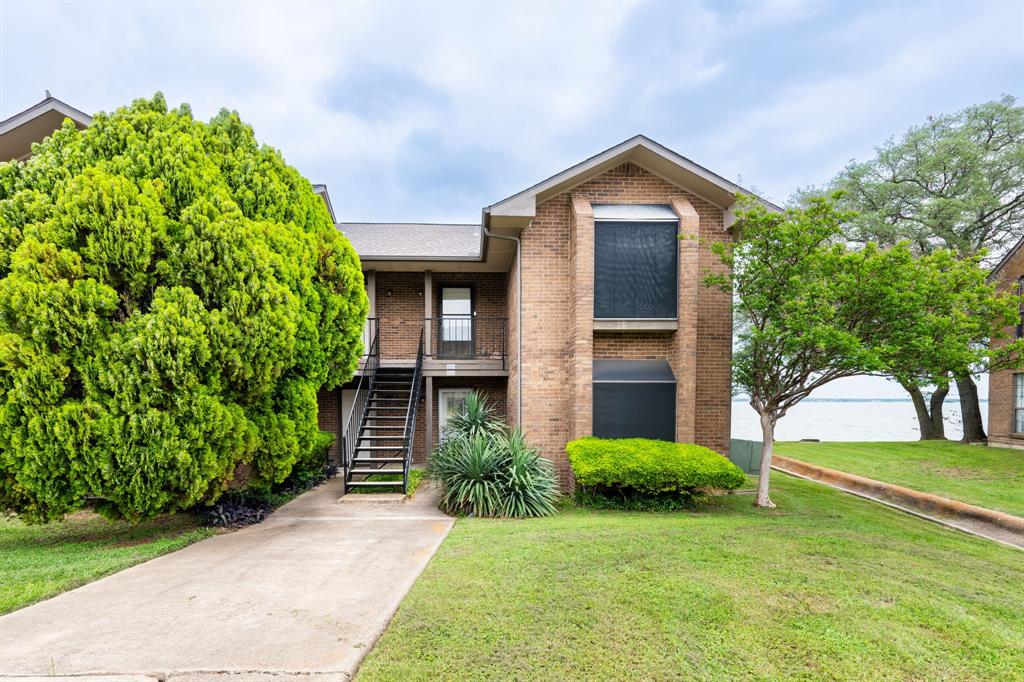 4610 Chaha Road, Unit 106 Garland, TX 75043 - Photo 2 of 25 a front view of a house with a yard and trees